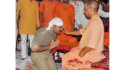 Police officer kneels down before CM Yogi, photos go viral Police officer kneels down before CM Yogi, photos go viral