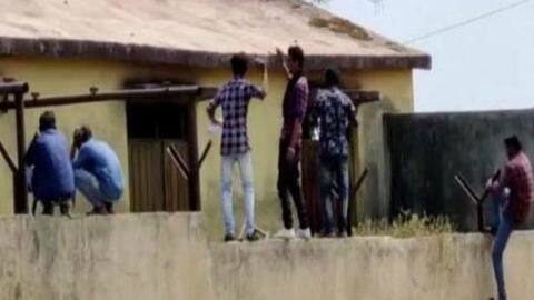 Watch: People climb Maharashtra school wall to help students cheat Watch: People climb Maharashtra school wall to help students cheat