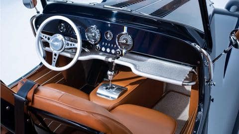 The car features retro-styled dials and leather upholstery 