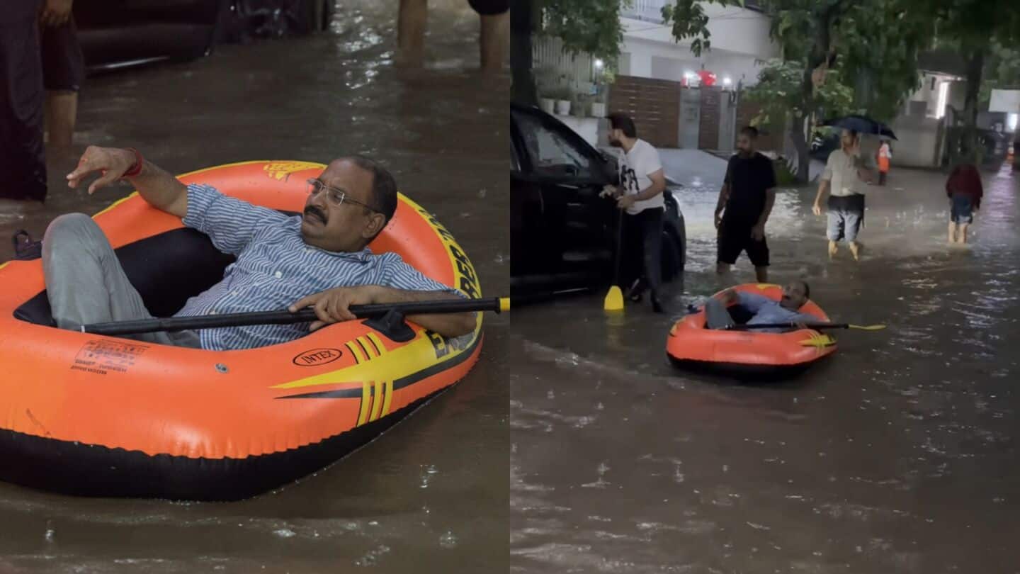 Man on raft pushed through flooded Greater Kailash Delhi street