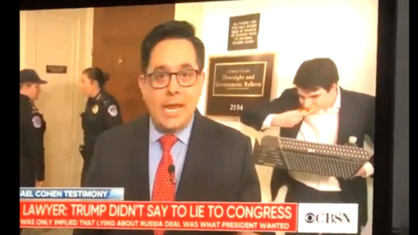 Hungry man eating pizza photobombs live reporting of Cohen testimony