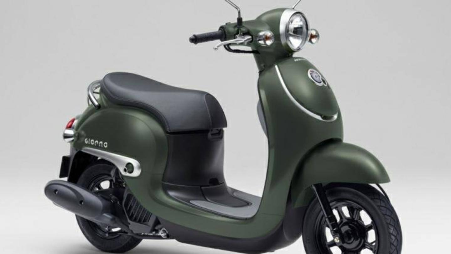 The scooter has a flat seat and round mirrors The scooter has a flat seat and round mirrors
