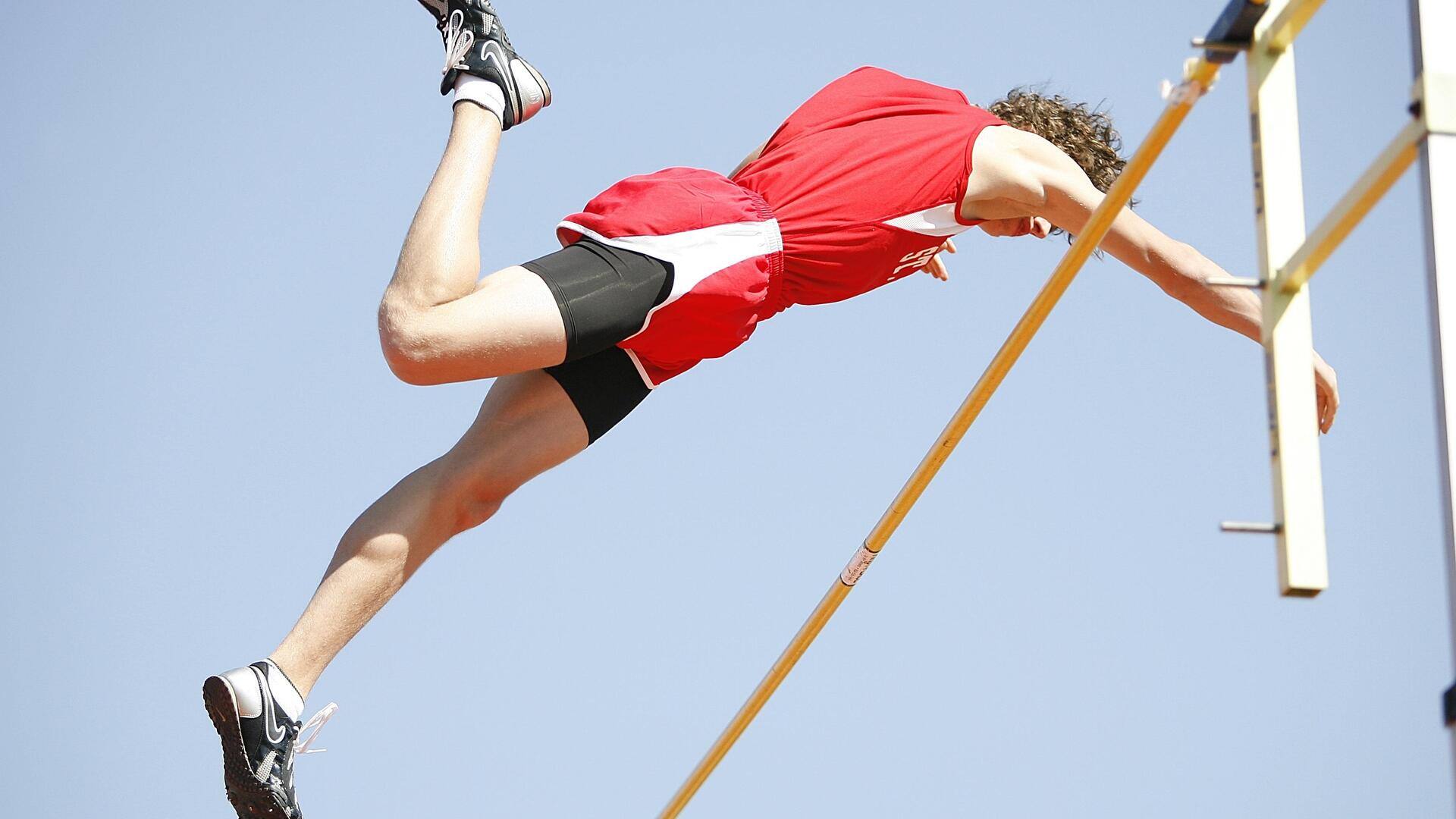 Mengapa lintasan melengkung digunakan dalam lompat tinggi Olimpiade?